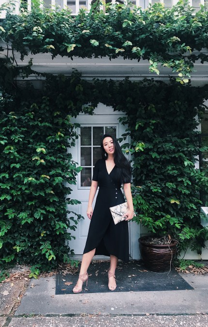 woman in black dress with faux reptile clutch