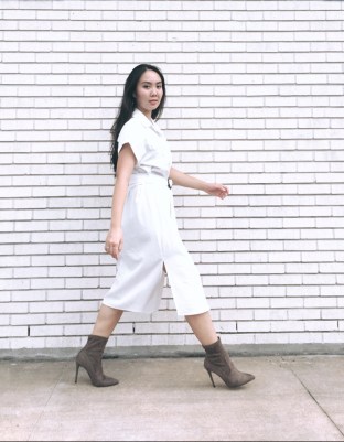 Woman walking in taupe booties and wearing a white dress